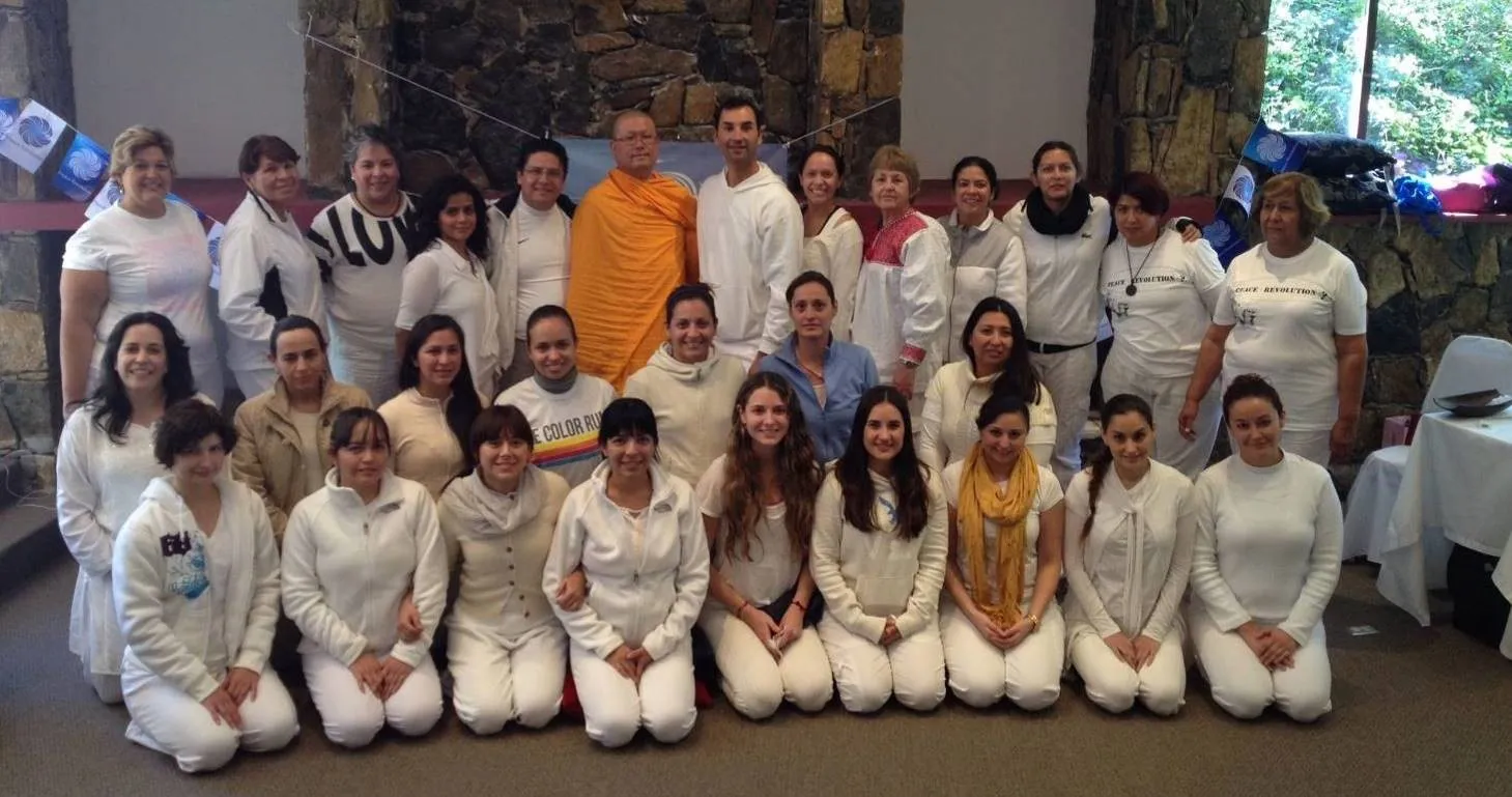The retreat participants dressed in white, gathered around the monk