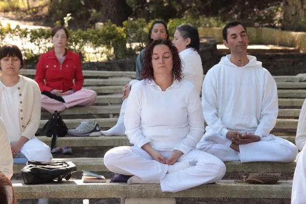 Participants meditating outdoors on stone steps at Chipinque